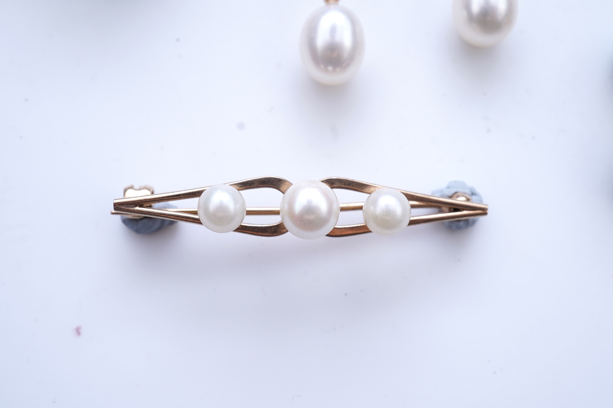A group of cultured pearl jewels, comprising: two pairs of cultured pearl drop earrings, longest 3cm, mounted in gold; and two cultured pearl brooches mounted in 9ct gold, longest 4.1cm, British hallmarks, combined gross